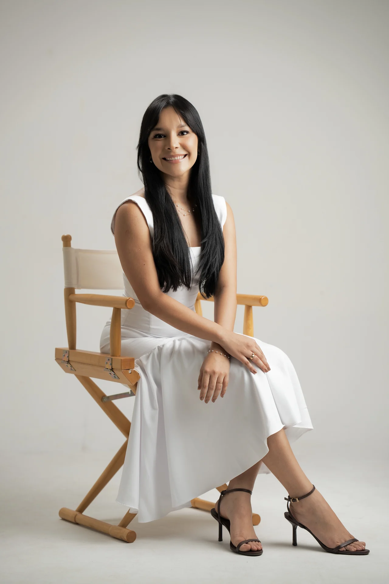 Dra. Geovana Paz sentada em uma cadeira de madeira